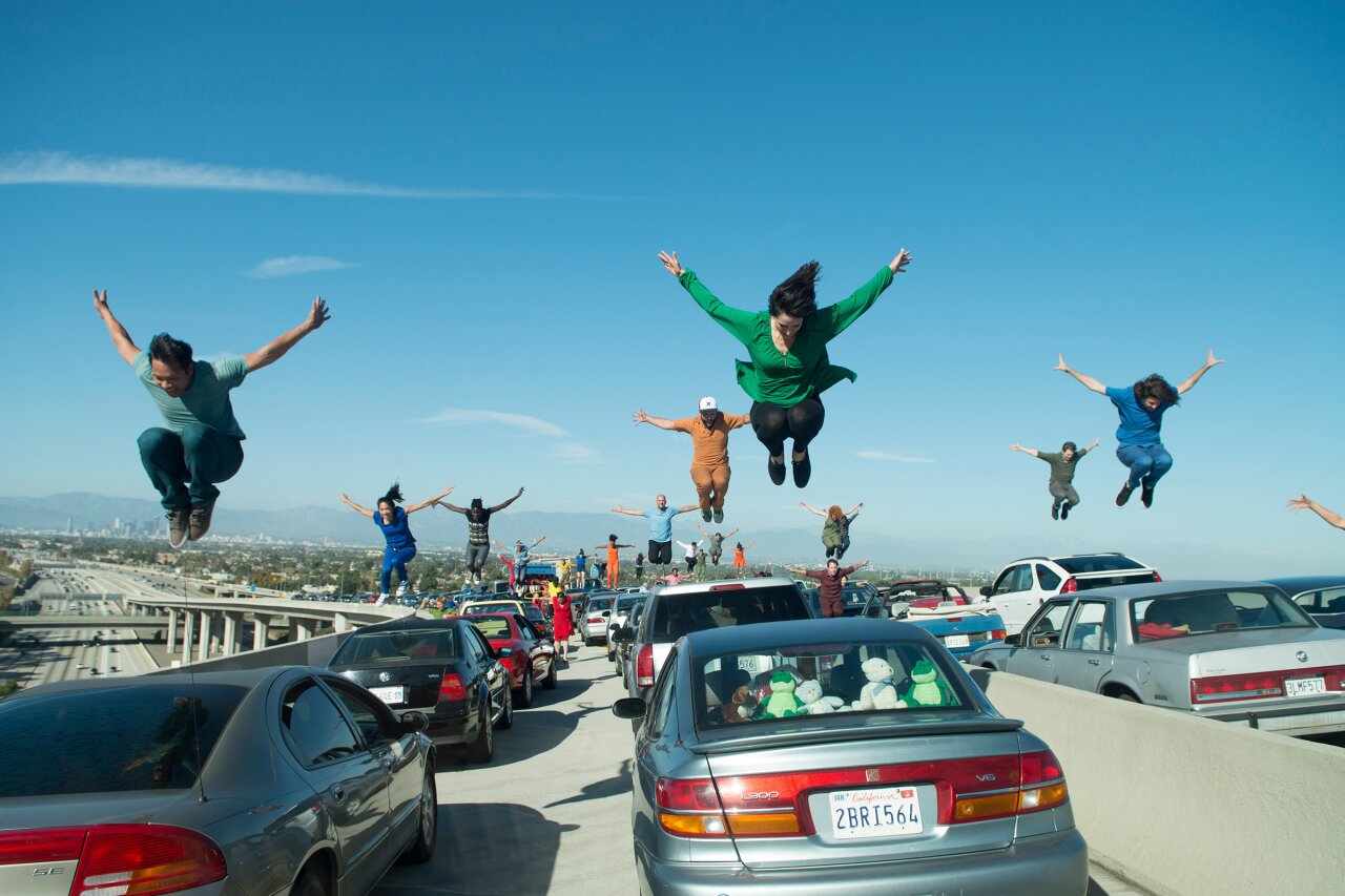 Openingsscène van La la Land. Mensen dansen bovenop hun auto's, die stil staan op een viaduct.